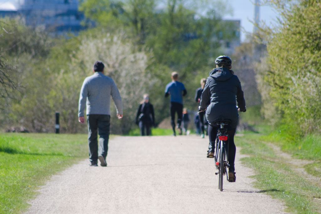 Personas ejercitándose aire libre, corriendo y andando en bicicleta 